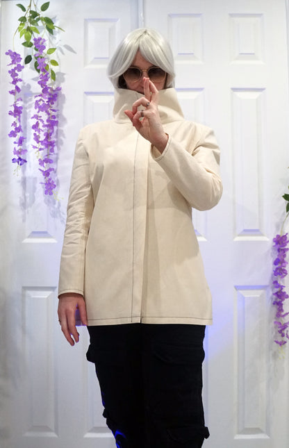 Person wearing a high-collar jacket with a front zipper, posing in front of white doors with purple floral decorations.
