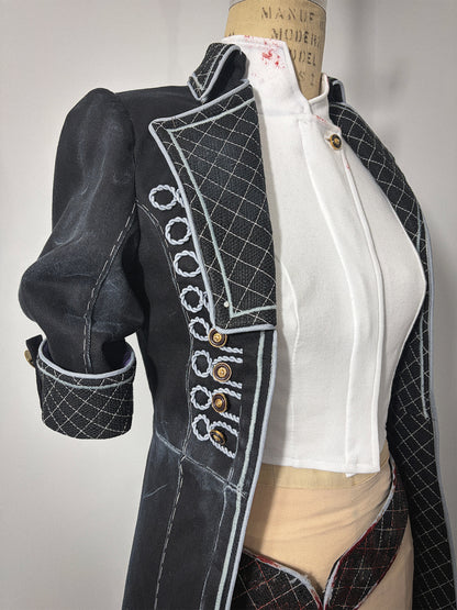 Close-up front view of the Lune jacket cosplay from Clair Obscur: Expedition 33 on a dress form, showing the right side bodice detail. Features decorative light grey corded button loops with gold buttons on the front panel, a quilted lapel, and an elbow-length sleeve with a quilted cuff and tab closure. A white undershirt is visible beneath the open front jacket.
