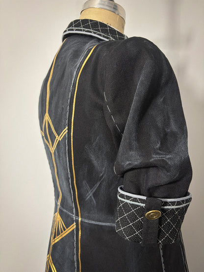 Close-up three-quarter back view of the Lune jacket cosplay from Clair Obscur: Expedition 33 on a dress form, highlighting the elbow-length sleeve and quilted cuff with its tab and gold button closure. Gold geometric designs and the princess seam are visible along the back bodice panel. The quilted collar is partially visible at the neckline.